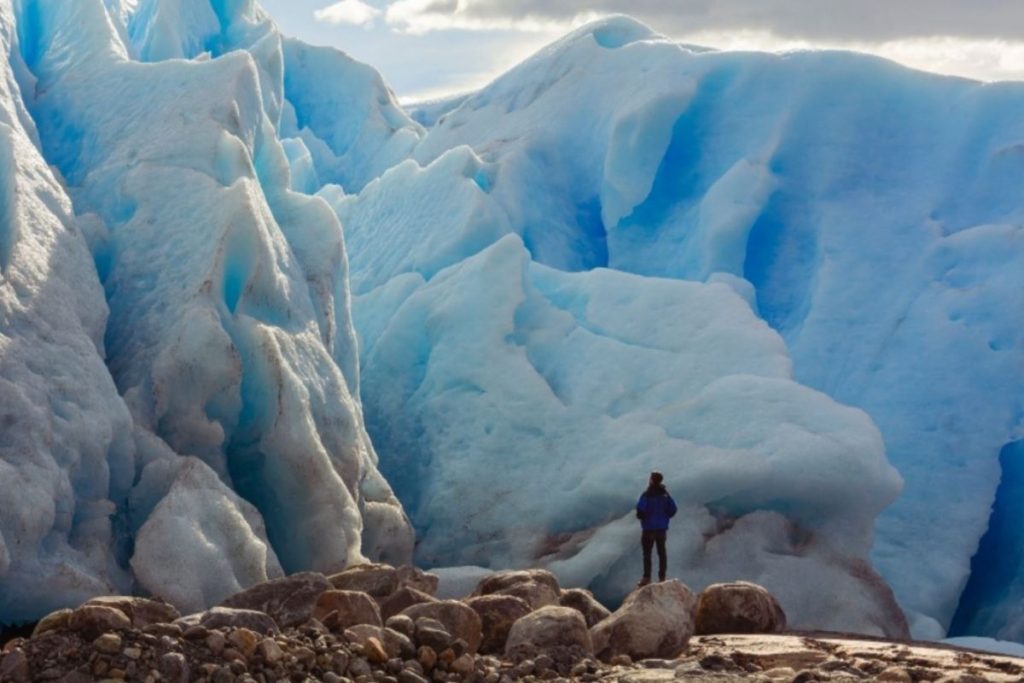 Glaciar de fondo con persona parada frente 