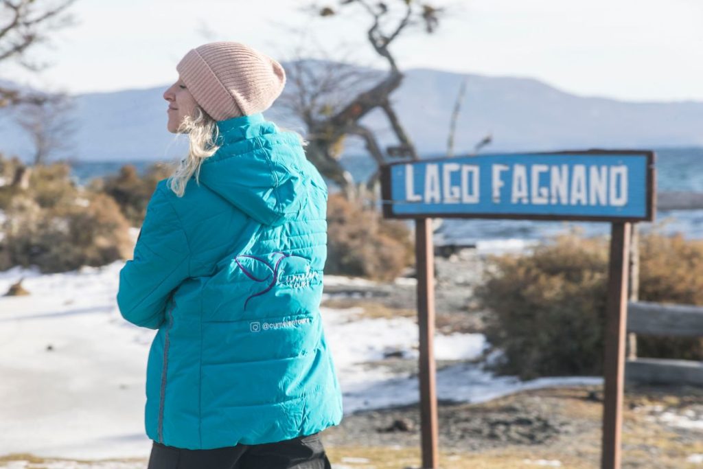 Persona con campera turquesa disfrutando del Lago Fagnano